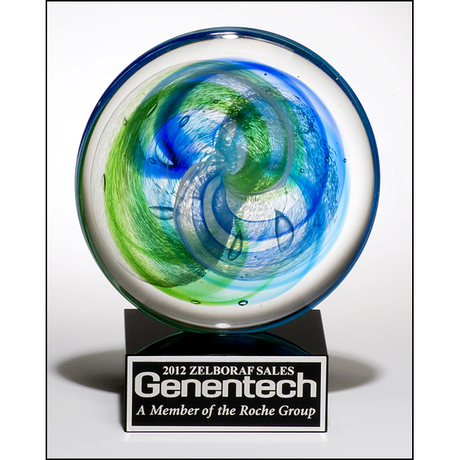 Art glass disk with blue and light green accents on black glass base with felt bottom.