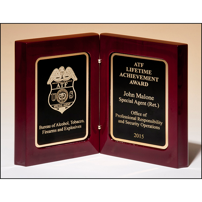 High gloss rosewood stained book award. Two gold plates with black centers.