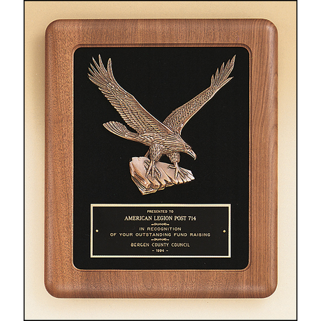 American walnut frame with a sculptured relief eagle casting on a black velour background.